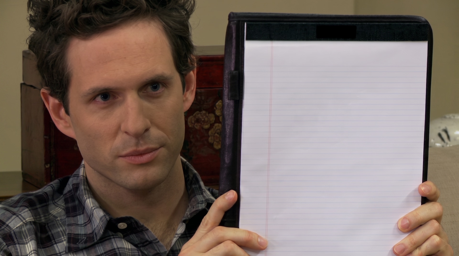 Dennis Reynolds holding up a notepad